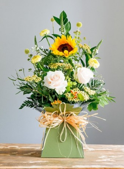 Yellow Box - Box of flowers in sunny, yellow and cream shades.

Shown here with Summer flower varieties, these may vary depending on the season. It is a lovely arrangement of flowers in cheerful colours, arranged in oasis with water and presented in a box with raffia or ribbon bow. Your florist will choose a selection of the freshest flowers available and create your gift in a front facing design. We are happy for you to suggest your preferred colour scheme. Flower varieties may change from those shown but will always be selected from the best of the growing season, often including roses, lizianthus, berries, carnations, lysmachia, leucadendron, eucalyptus, ruscus and twigs or grasses. As the flowers are made within a presentation box which has water added, it makes them ideal for those customers who are travelling to visit friends or family, as their gift needs no further arranging by the recipient. Always eyecatching, always cheerful, pretty and scented. Flower varieties may vary from those shown but will be chosen to include a range of scented and longer lasting blooms. Ideal for a thank you or get well treat, to say "Happy Birthday" or "Well done".