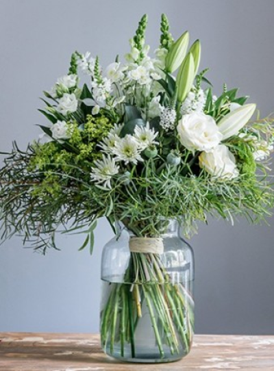 White Vase Bouquet - Glass vase of beautiful ivory and white flowers.

A hand-tied bouquet of mixed seasonal flowers in shades of white and cream with a variety of foliages, presented in a glass vase. Always including the freshest flowers of the season, for example lilies, roses, lizianthus, chrysanthemums, freesia, bloom chrysanthemums, eucalyptus, ruscus and grasses. We will choose a vase style to suit your tied bouquet, often made from eco-friendly recycled glass and using natural raffia or twine to tie the stems. Your florist will hand make your bouquet, spiralling the stems and tying them so that the flowers need no further arranging by the recipient. Always classy, always elegeant, fresh and simple. Flower varieties may vary from those shown but will be selected from the best of the growing season. Ideal for an anniversary or thank you treat, to say "Best wishes" or "Congratulations".